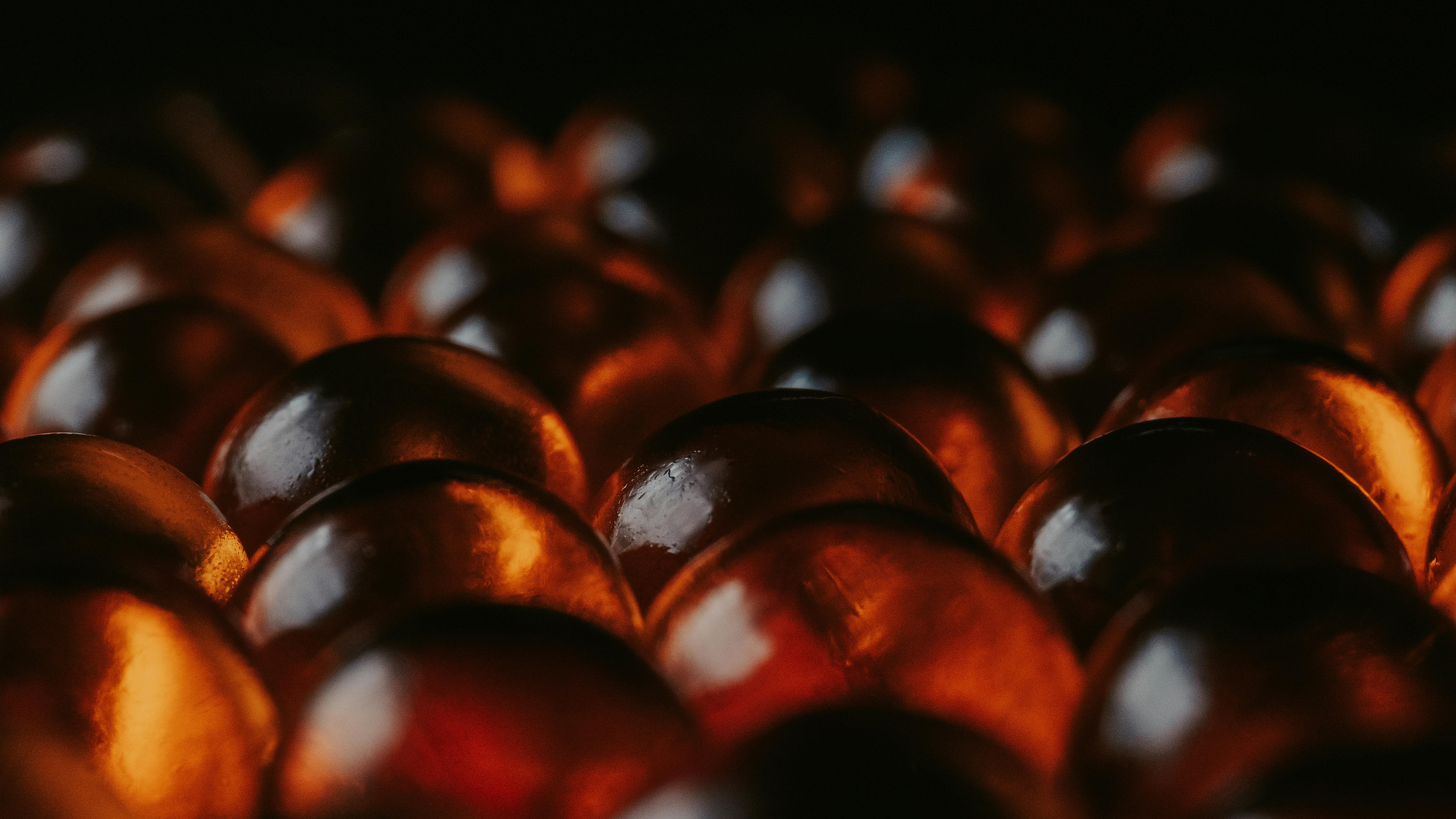 grátis Visão aproximada de esferas âmbar brilhantes sobre um fundo escuro, criando uma atmosfera acolhedora e melancólica. Foto profissional