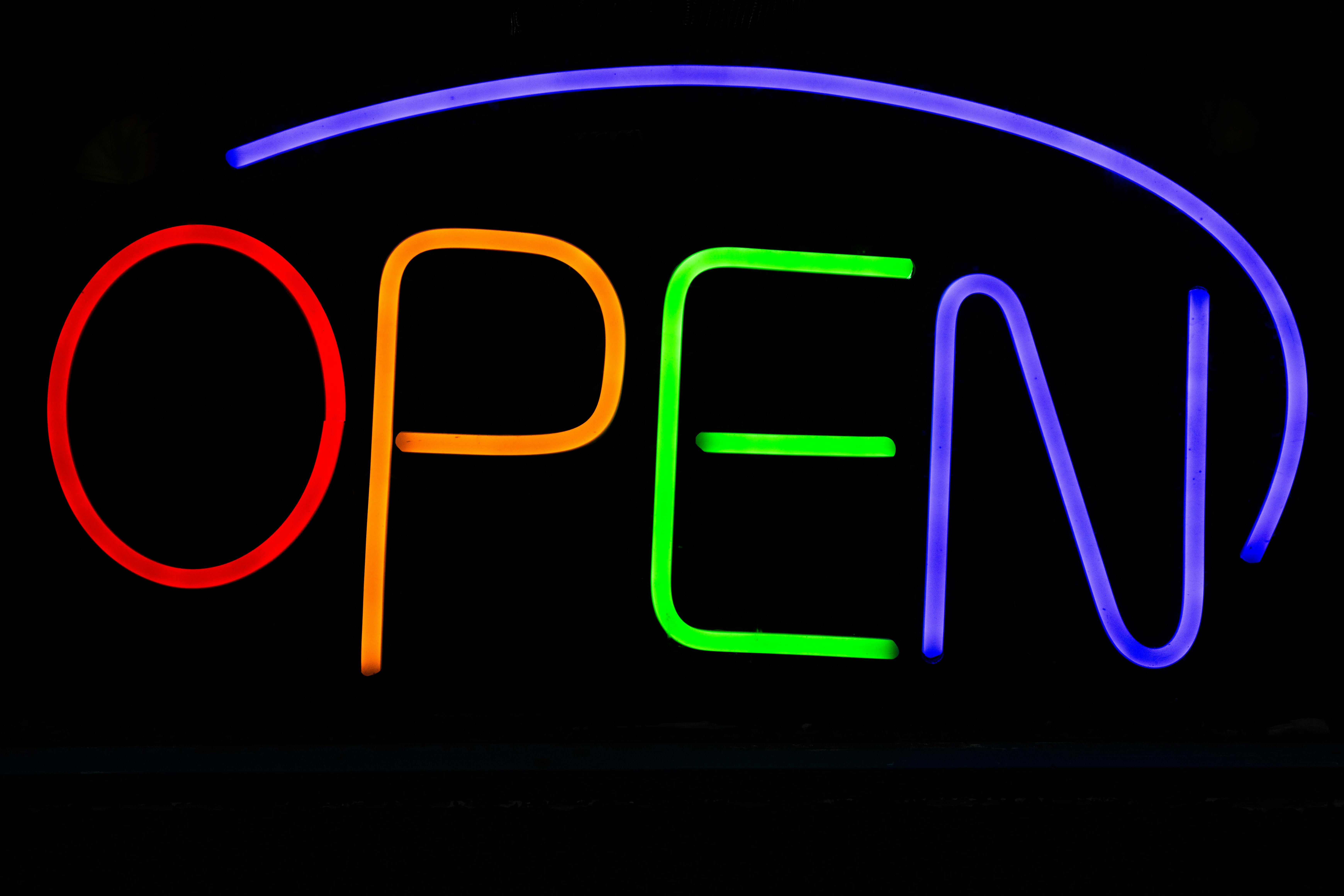Безкоштовне Яскравий неоновий напис «ВІДКРИТО» з різнокольоровими вогнями на чорному фоні. стокове фото