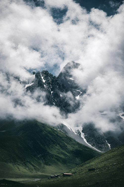 Free Majestic mountain peak shrouded in clouds, offering a serene and dramatic view. Stock Photo