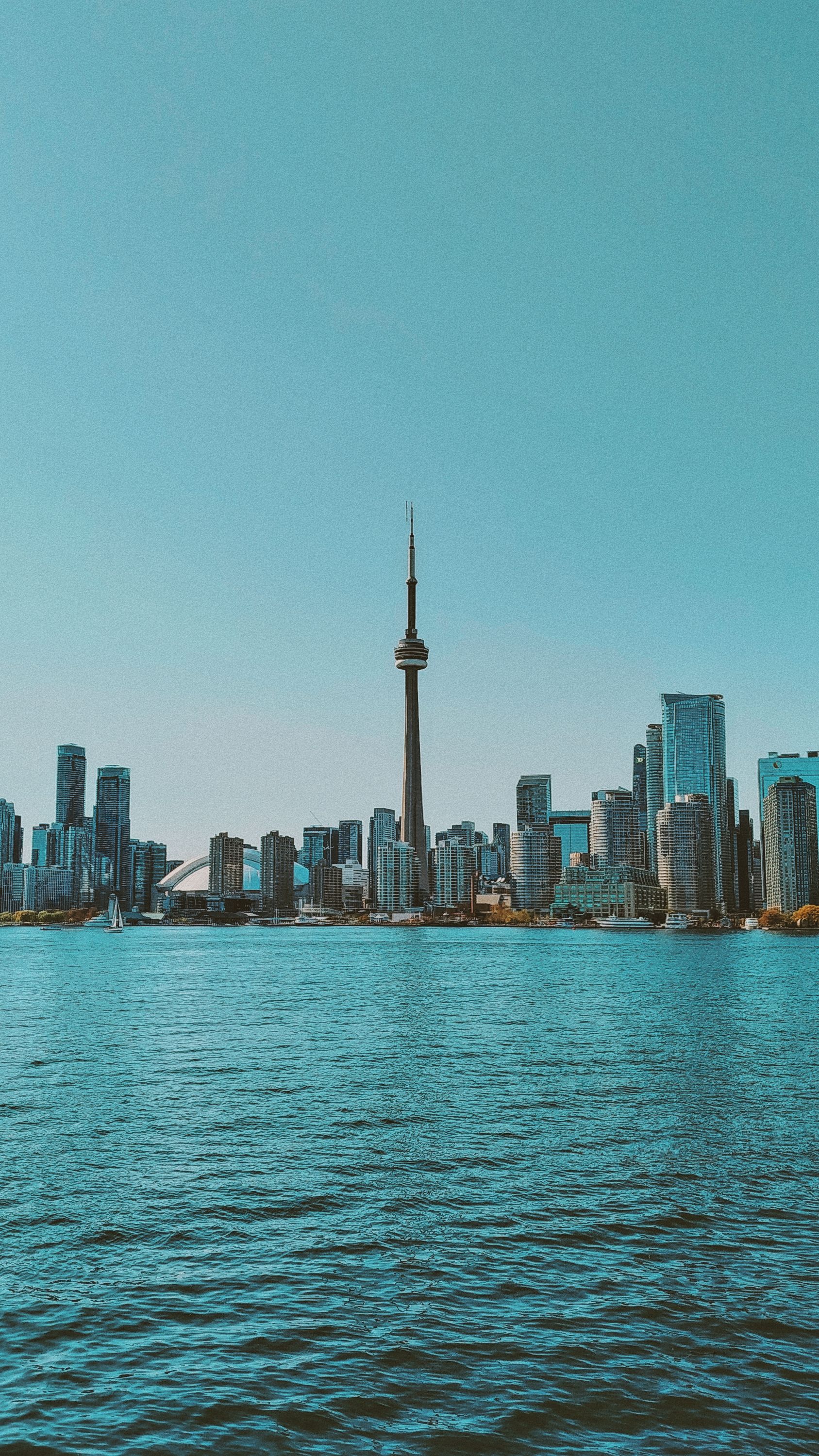 Breathtaking view of Toronto's skyline featuring the iconic CN Tower across Lake Ontario.