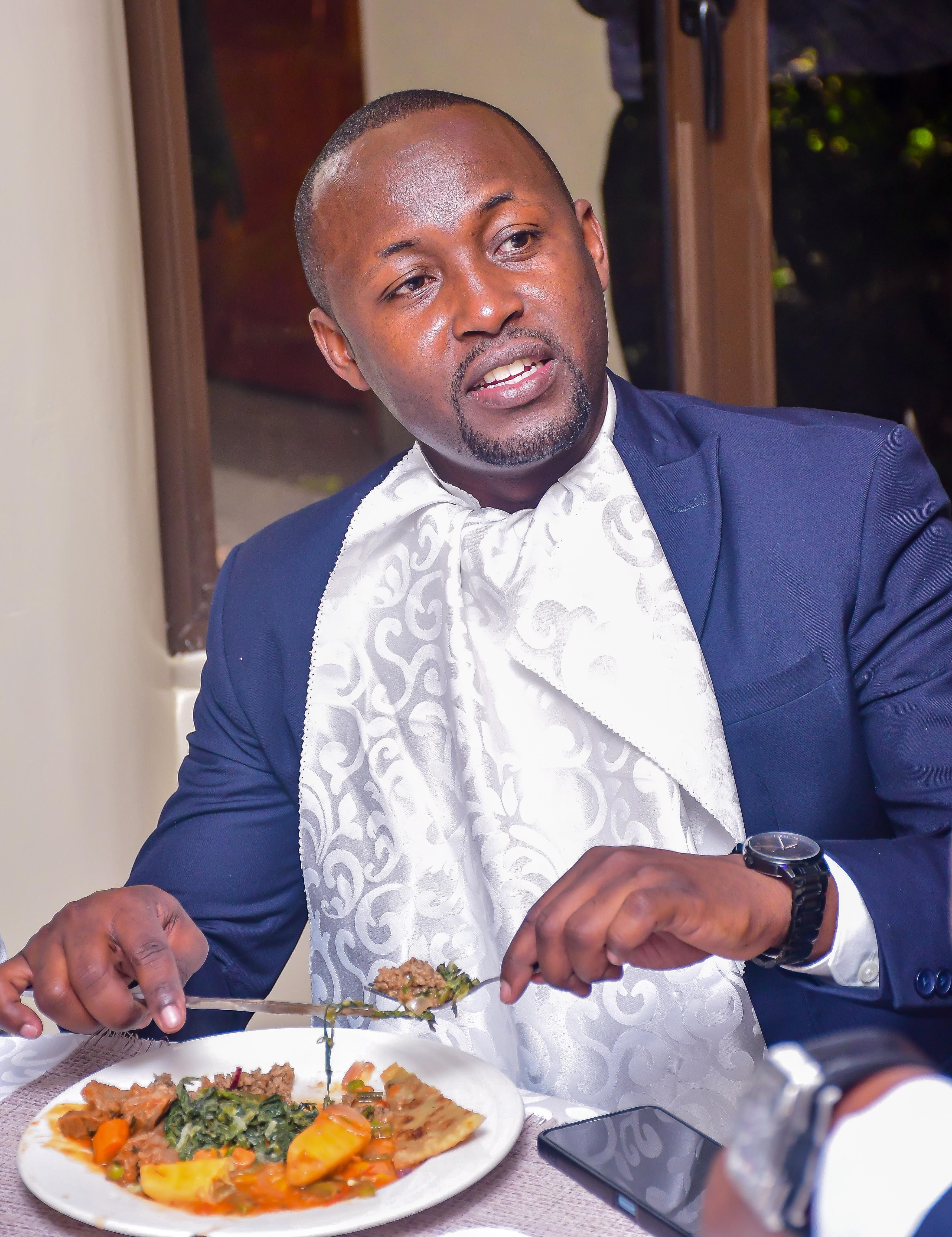 Man in formal attire enjoying a meal, exuding elegance and sophistication indoors.