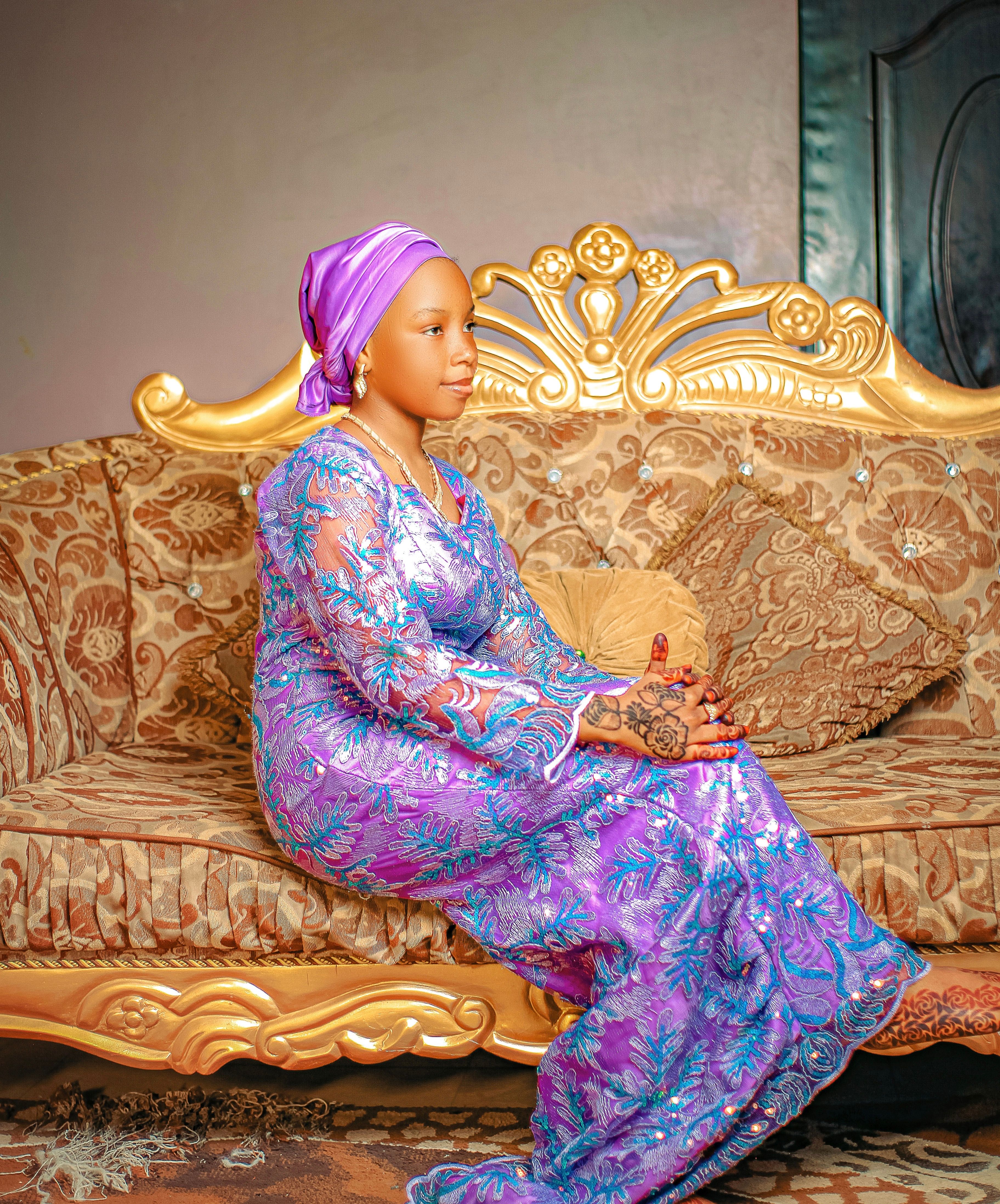 Elegant Woman in Traditional African Attire on Sofa · Free Stock Photo