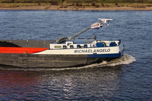 Free A cargo ship named 'MICHAELANGELO' navigating a calm waterway, ideal for transportation themes. Stock Photo