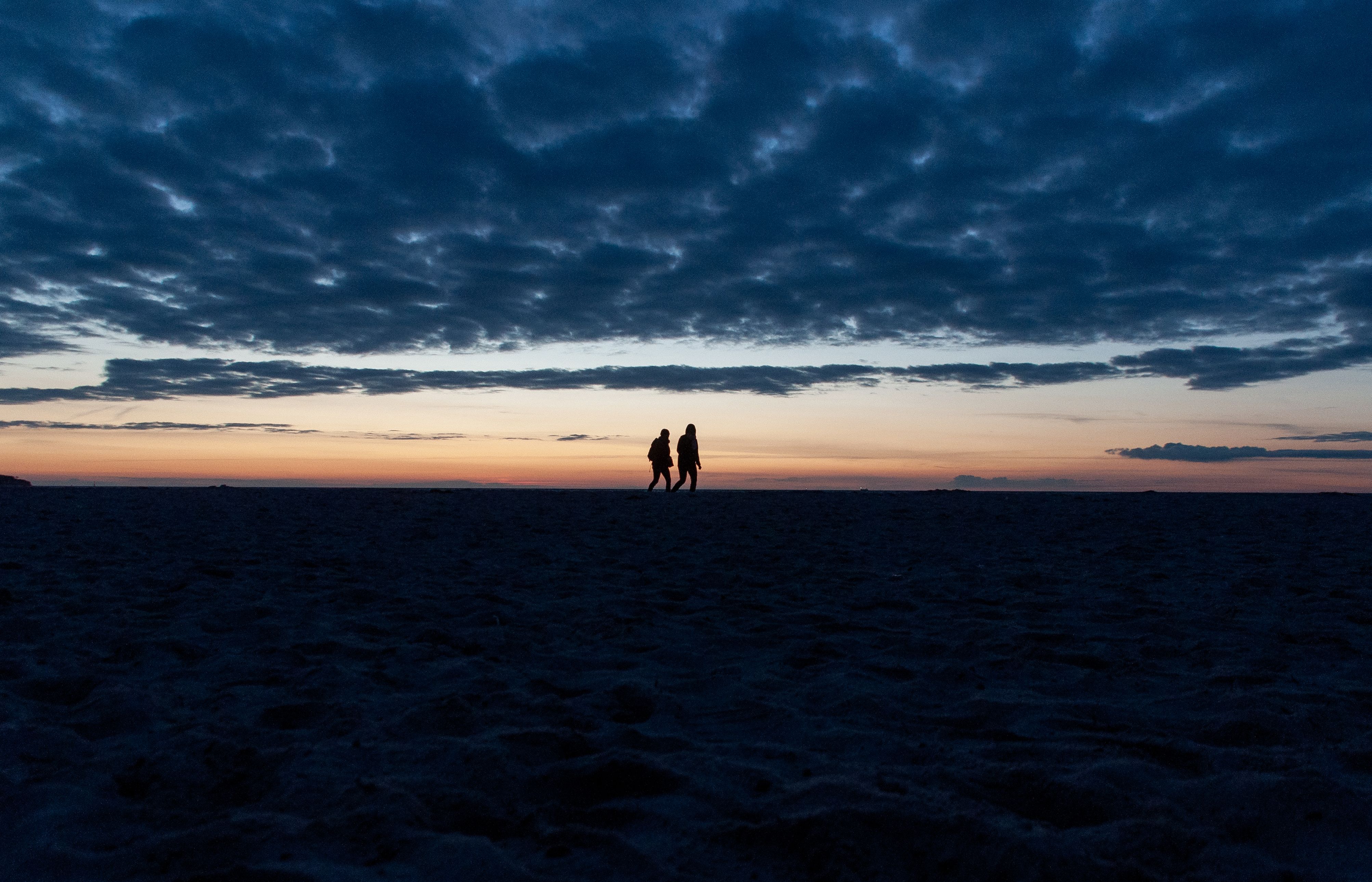 Silhouette of People Walking on Beach at Sunset · Free Stock Photo