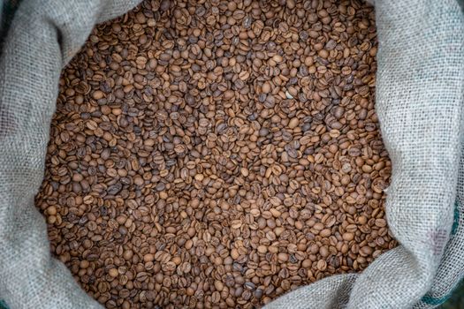 A burlap sack filled with aromatic, freshly roasted coffee beans, perfect for brewing.