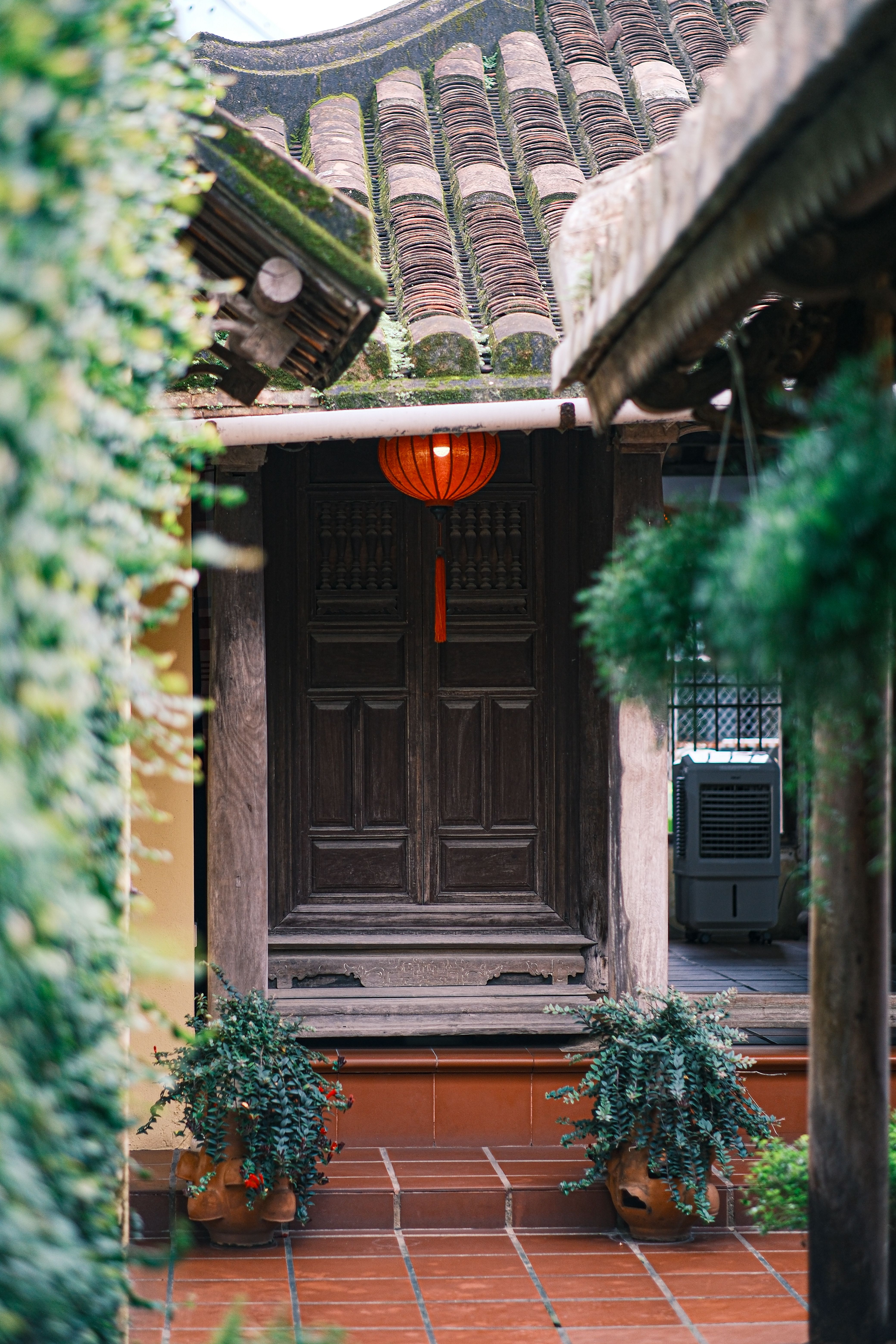 grátis Uma vista panorâmica da arquitetura tradicional asiática, com destaque para uma porta de madeira e uma lanterna suspensa. Foto profissional