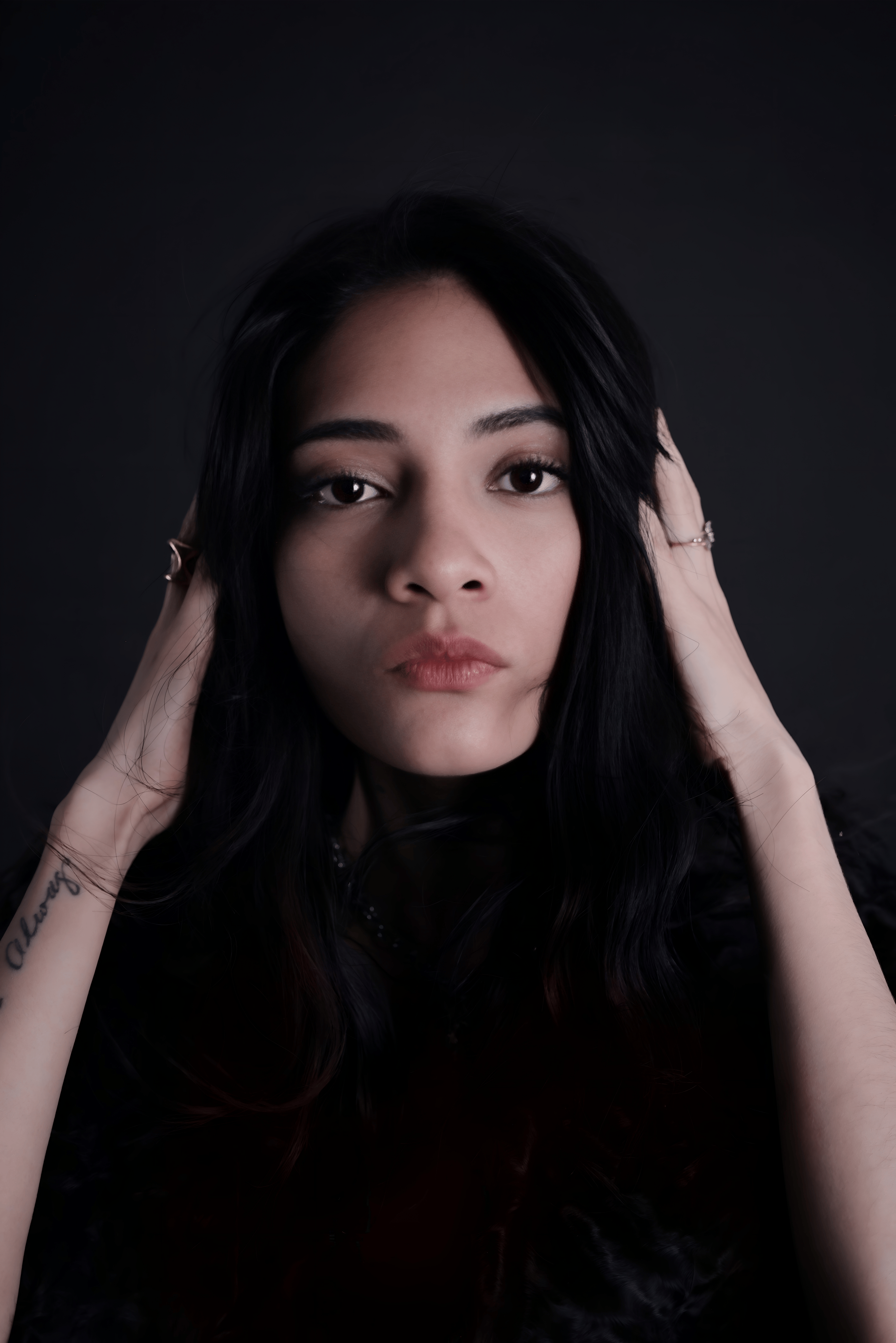 Kostnadsfria Fängslande porträtt av en kvinna i studiobelysning med ett kontemplativt uttryck. Stock foto