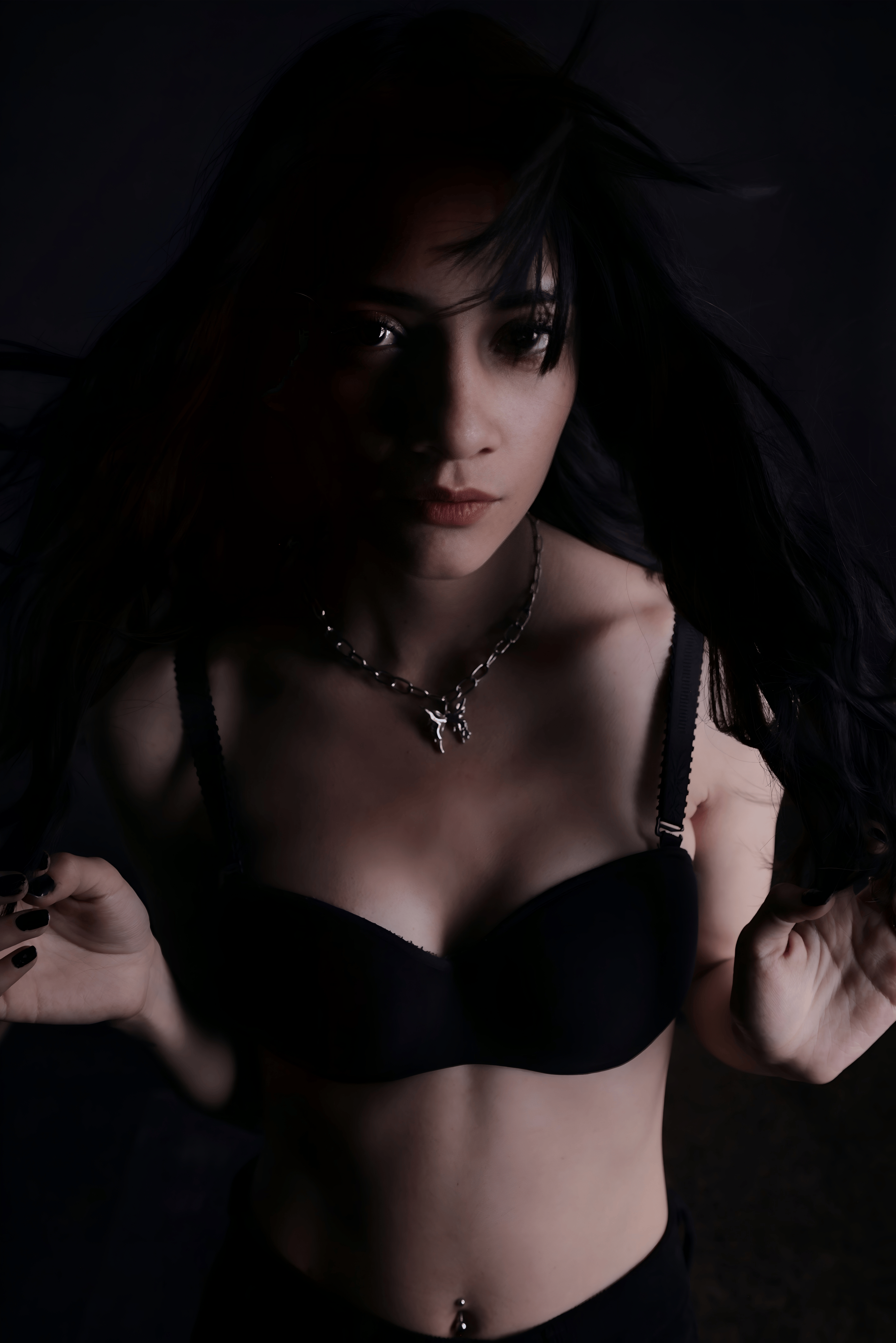 Безкоштовне Художній портрет жінки з чорним волоссям при слабкому освітленні, що створює відчуття таємничості. стокове фото