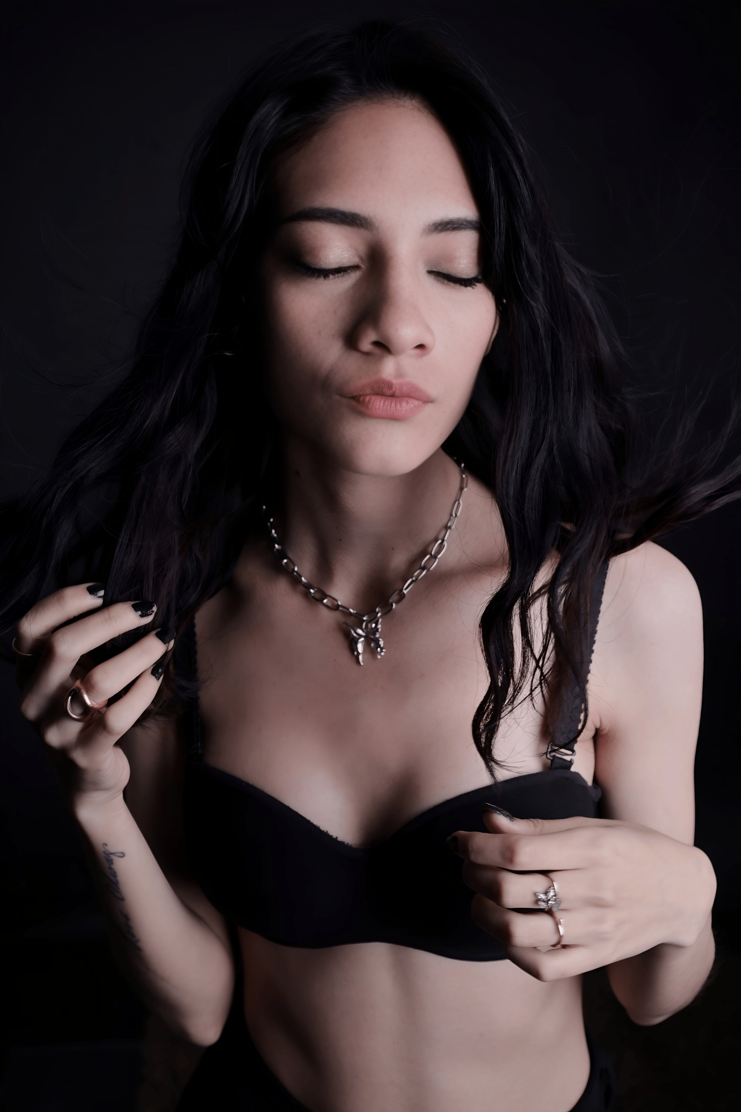 Gratis Elegante ritratto di una donna che mette in mostra i gioielli in un ambiente con luce soffusa. Foto a disposizione