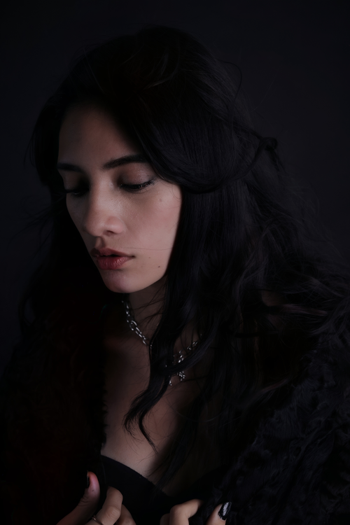 Free A thoughtful woman in dark lighting creating an intimate, moody atmosphere. Stock Photo