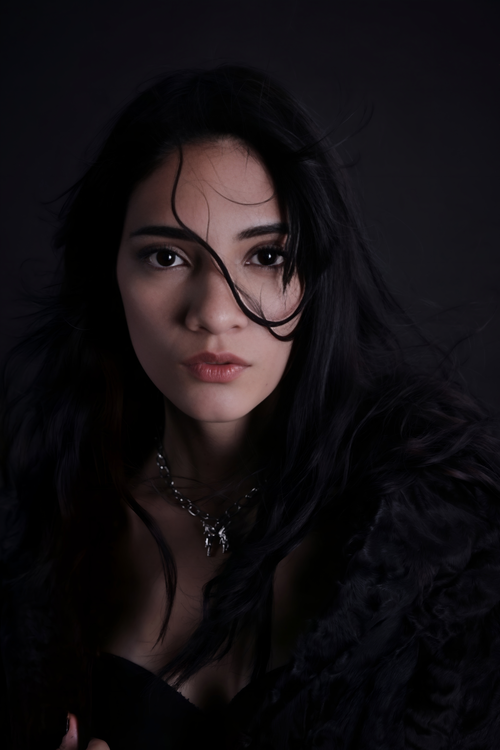 Free A dramatic portrait of a woman with dark hair and expressive gaze. Stock Photo