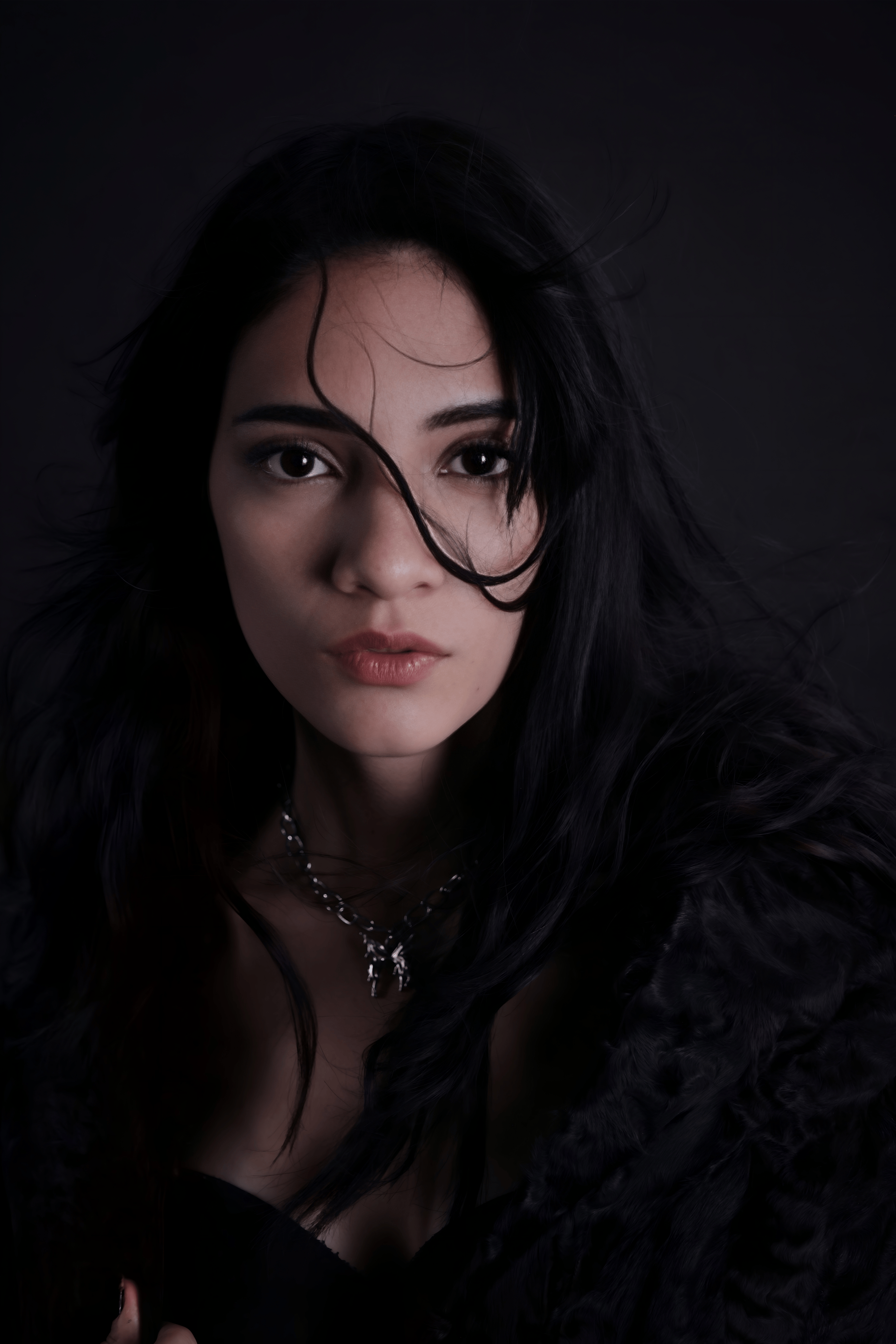 Gratis Un ritratto drammatico di una donna con capelli scuri e sguardo espressivo. Foto a disposizione