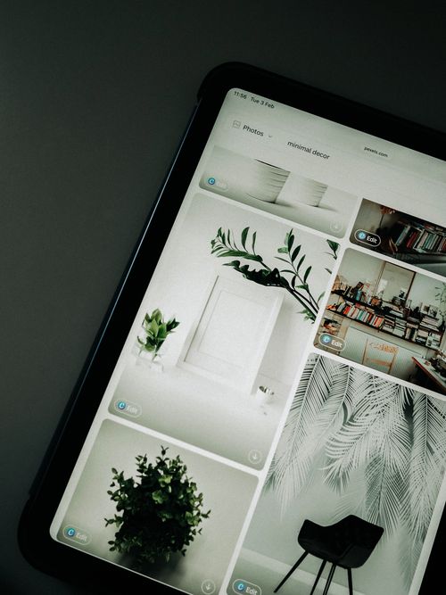 Free A tablet screen featuring images of minimalist decor emphasizing greenery and simple design. Stock Photo
