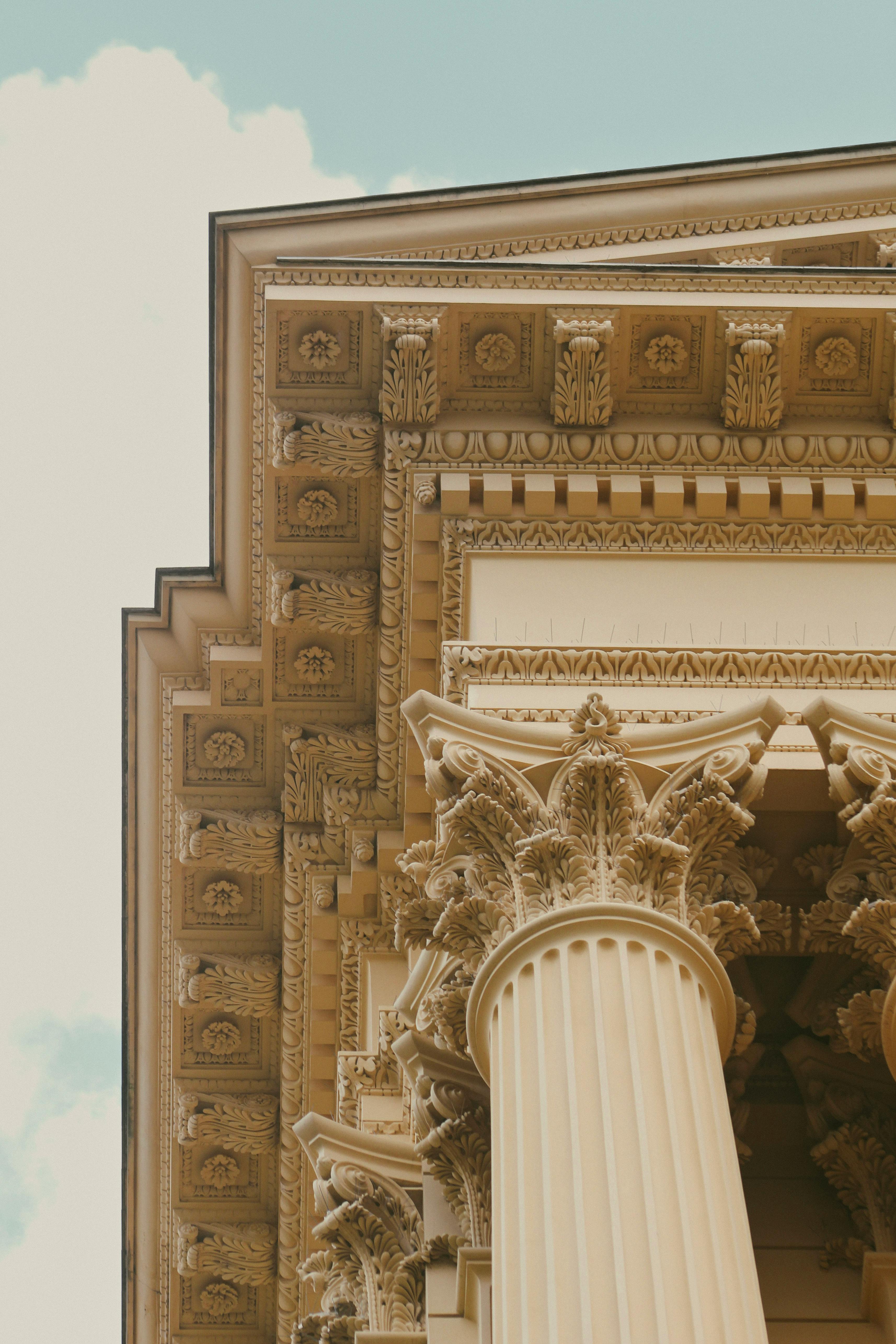Free Detailed view of classical architecture with ornate columns and carvings under a clear sky. Stock Photo