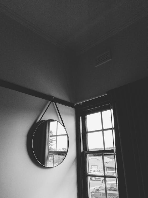 Grayscale Photo of Round Mirror