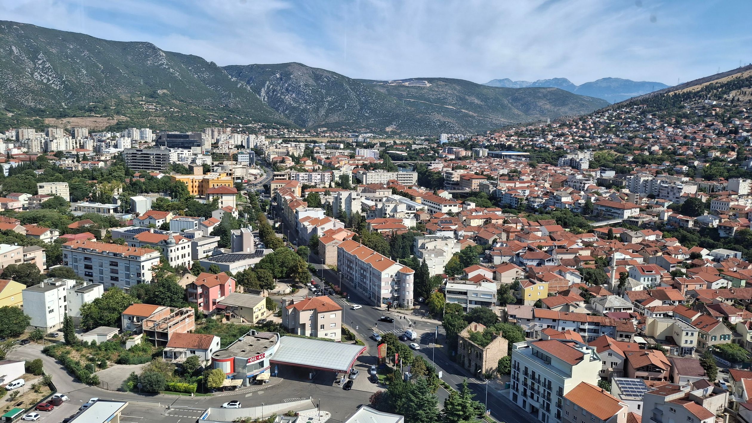 Aerial shot capturing Sarajevo's scenic old town with surrounding mountains.