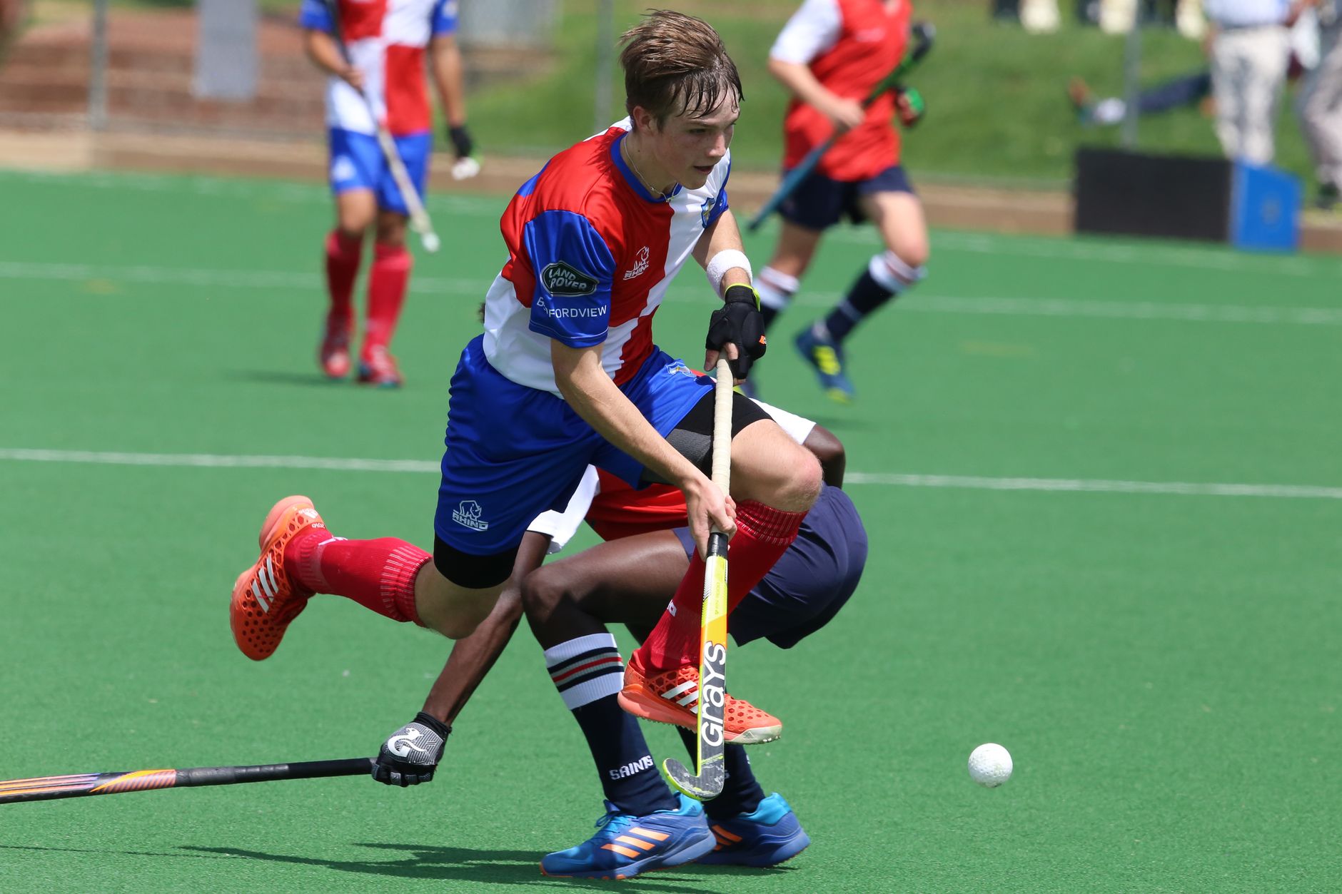 Dynamic field hockey action capturing players in motion during a competitive match.