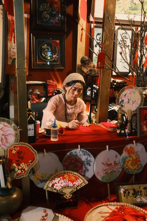 Free Woman artist creating calligraphy in a traditional art shop setting. Stock Photo