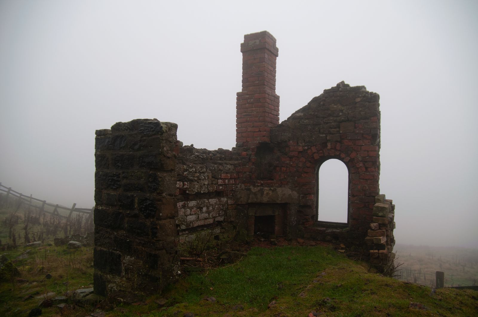 Eerie mist surrounds the ruins of an old stone structure in England, creating a desolate a, by Damien Wright on Pexels