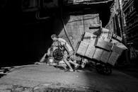 Worker Pulling Cart in Urban Street Scene