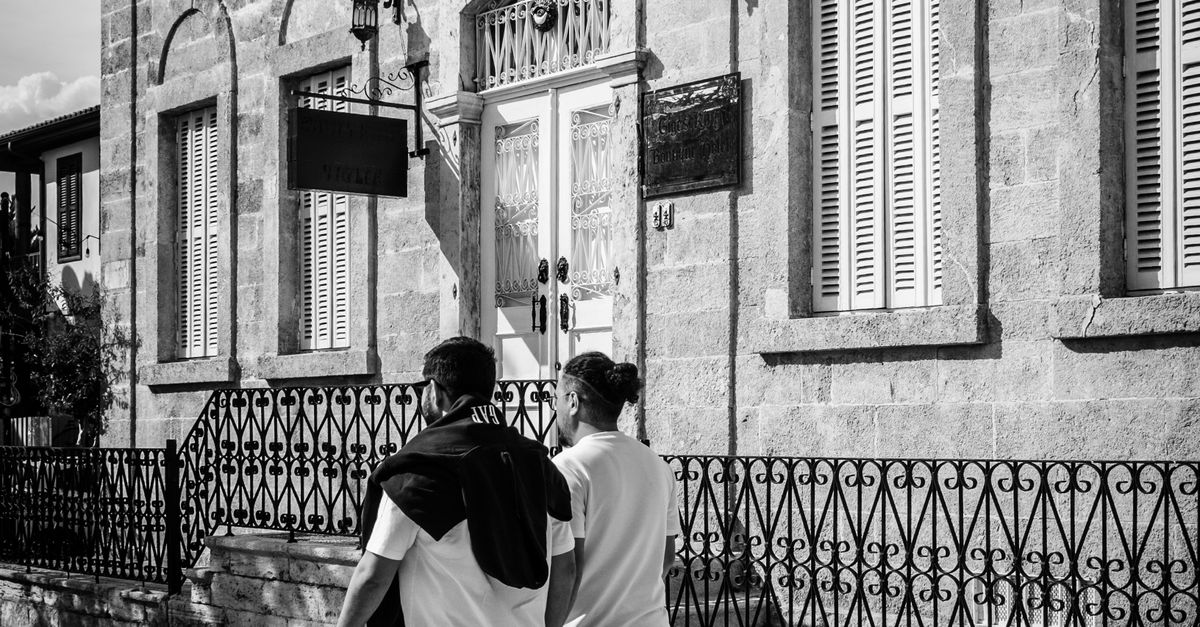 Two People Walking Past Historic Building · Free Stock Photo