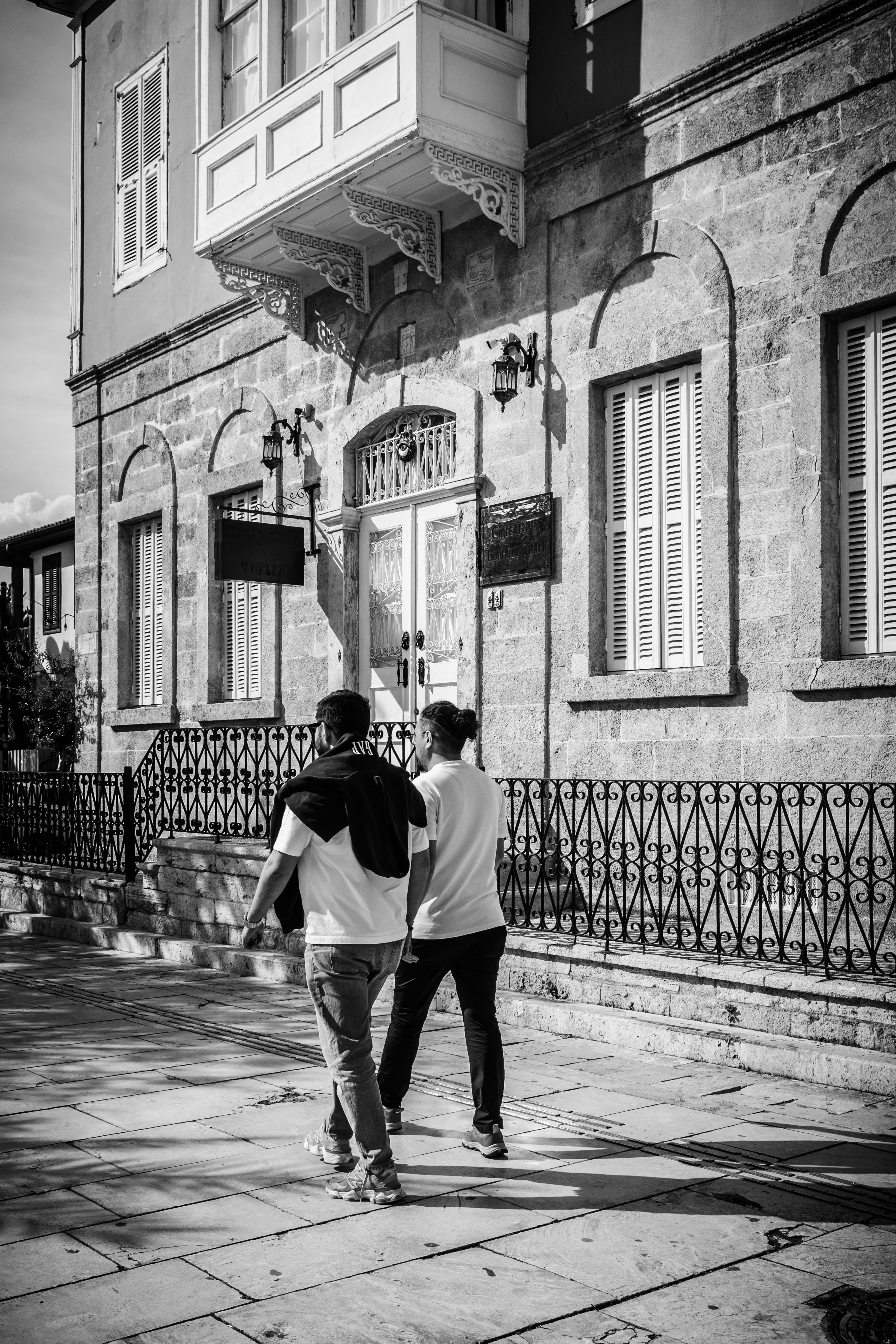 Two People Walking Past Historic Building · Free Stock Photo