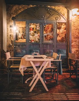 Charming outdoor café with vintage decor and warm lighting, perfect for an evening dining experience.