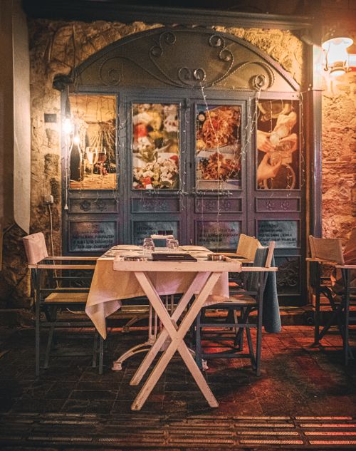 Free Charming outdoor café with vintage decor and warm lighting, perfect for an evening dining experience. Stock Photo