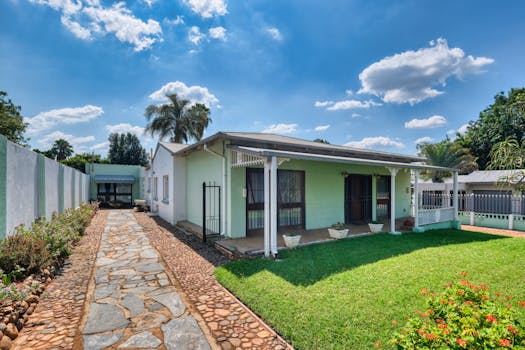 Exterior view of a cozy house with a lush garden under a clear sky.