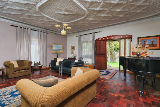 Spacious living room featuring elegant decor, grand piano, and warm lighting.