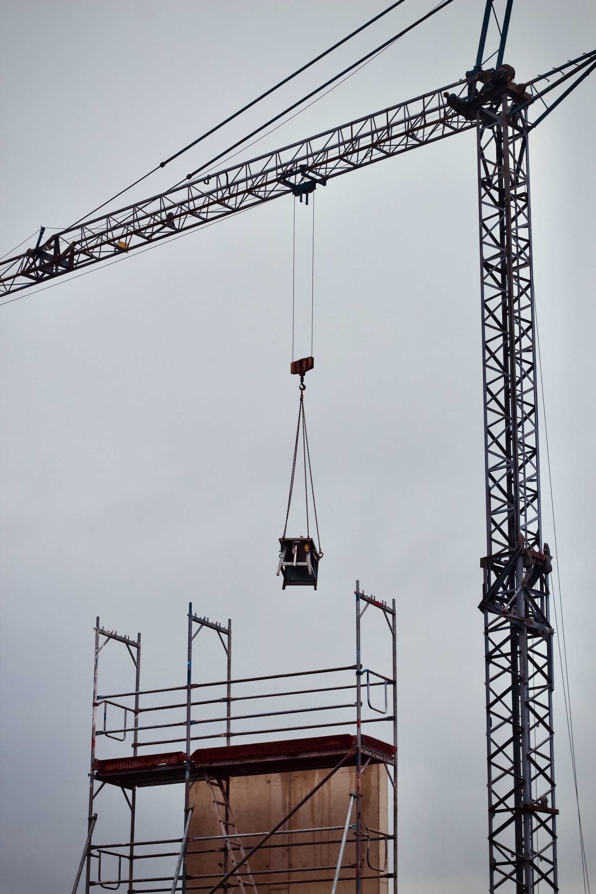 Tower crane lifting materials on a construction site