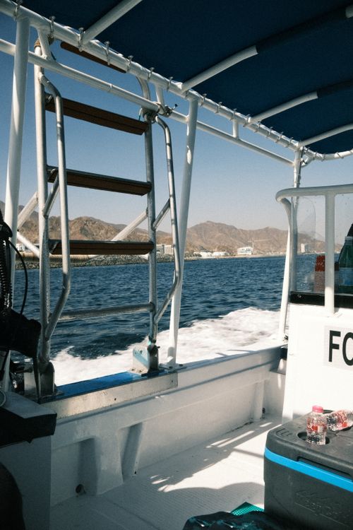 Free Enjoy a sunny boat ride overlooking mountains in UAE's serene waters. Stock Photo