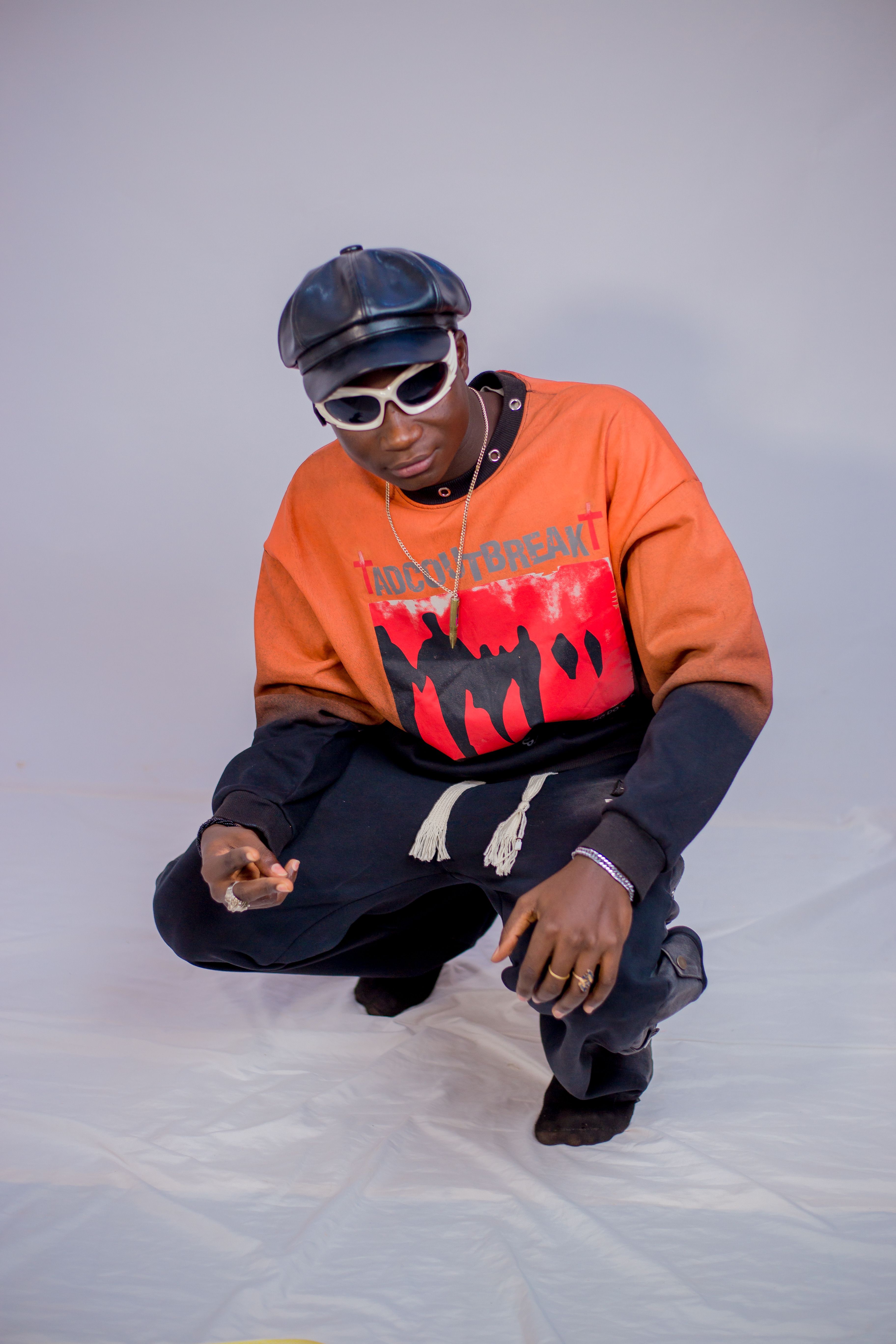 Shot of a stylish black man wearing modern urban streetwear with sunglasses and a cap.