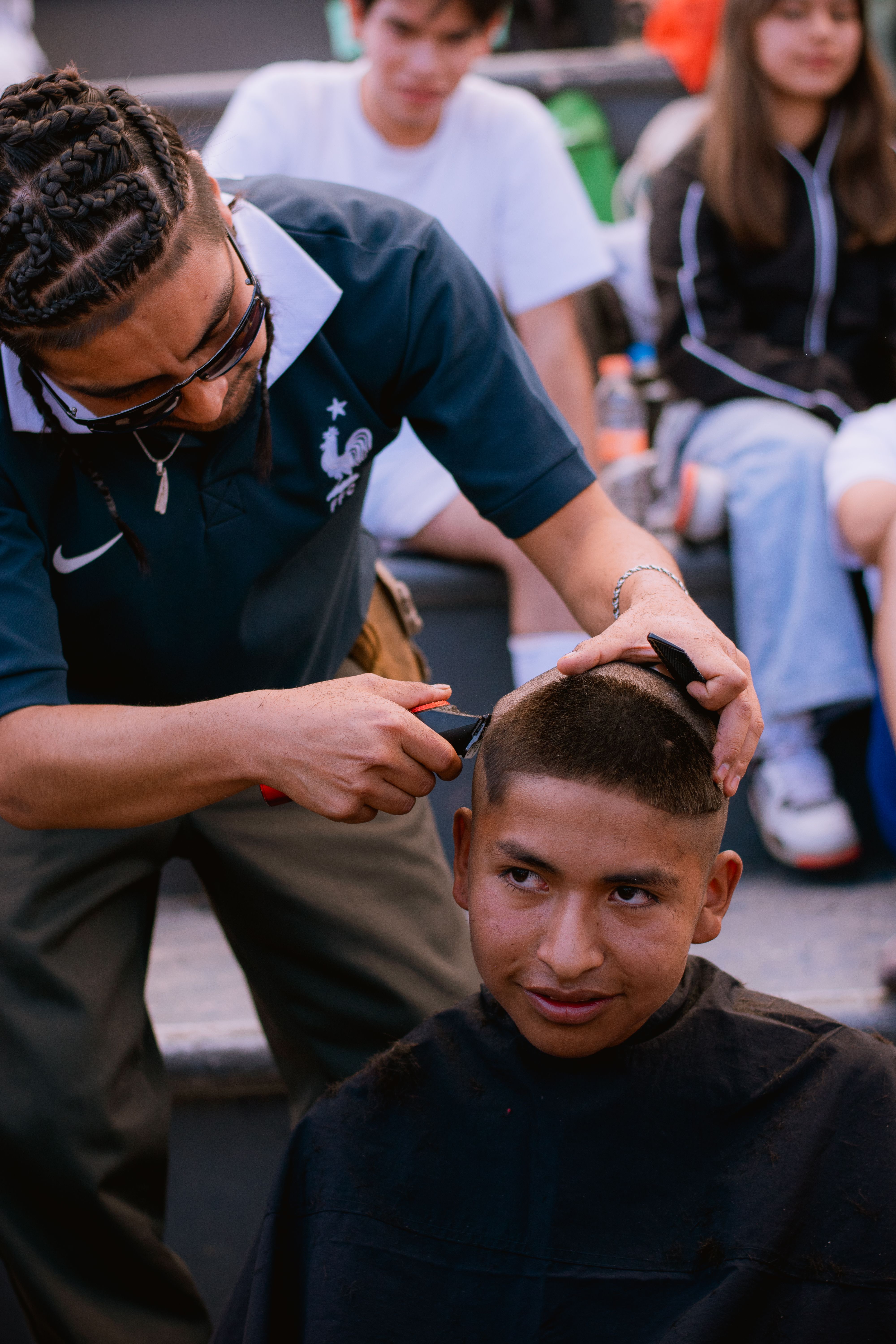 Barber cutting a man’s hair outdoors, creating a casual and spontaneous street vibe.