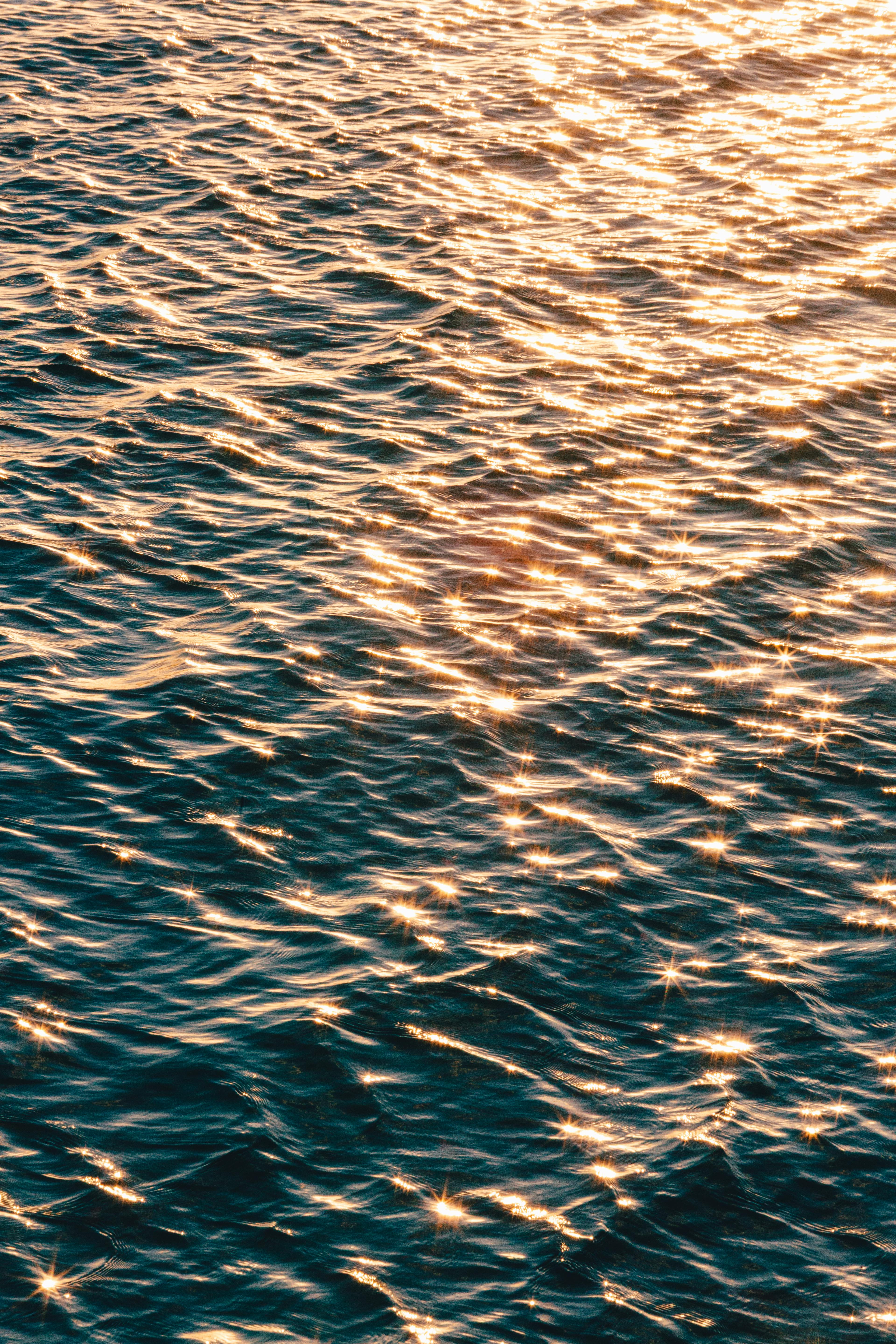 Безкоштовне Захопливий вид сонячних хвиль, що створюють мерехтливу текстуру на поверхні океану. стокове фото