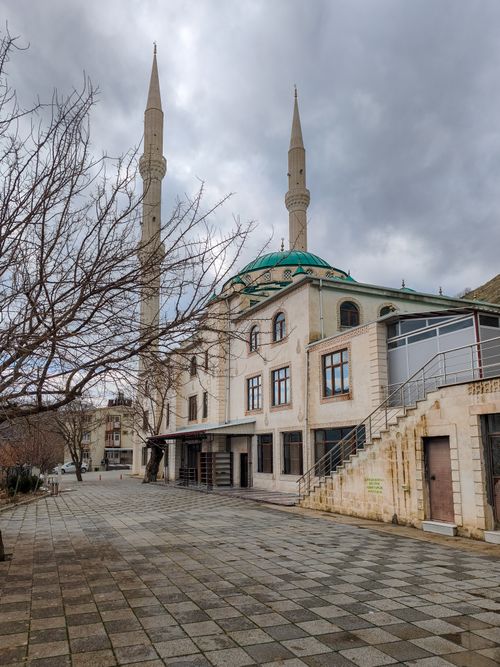 Free A beautiful mosque in Palu, Elazığ, Türkiye featuring minarets and a dome under a cloudy sky. Stock Photo