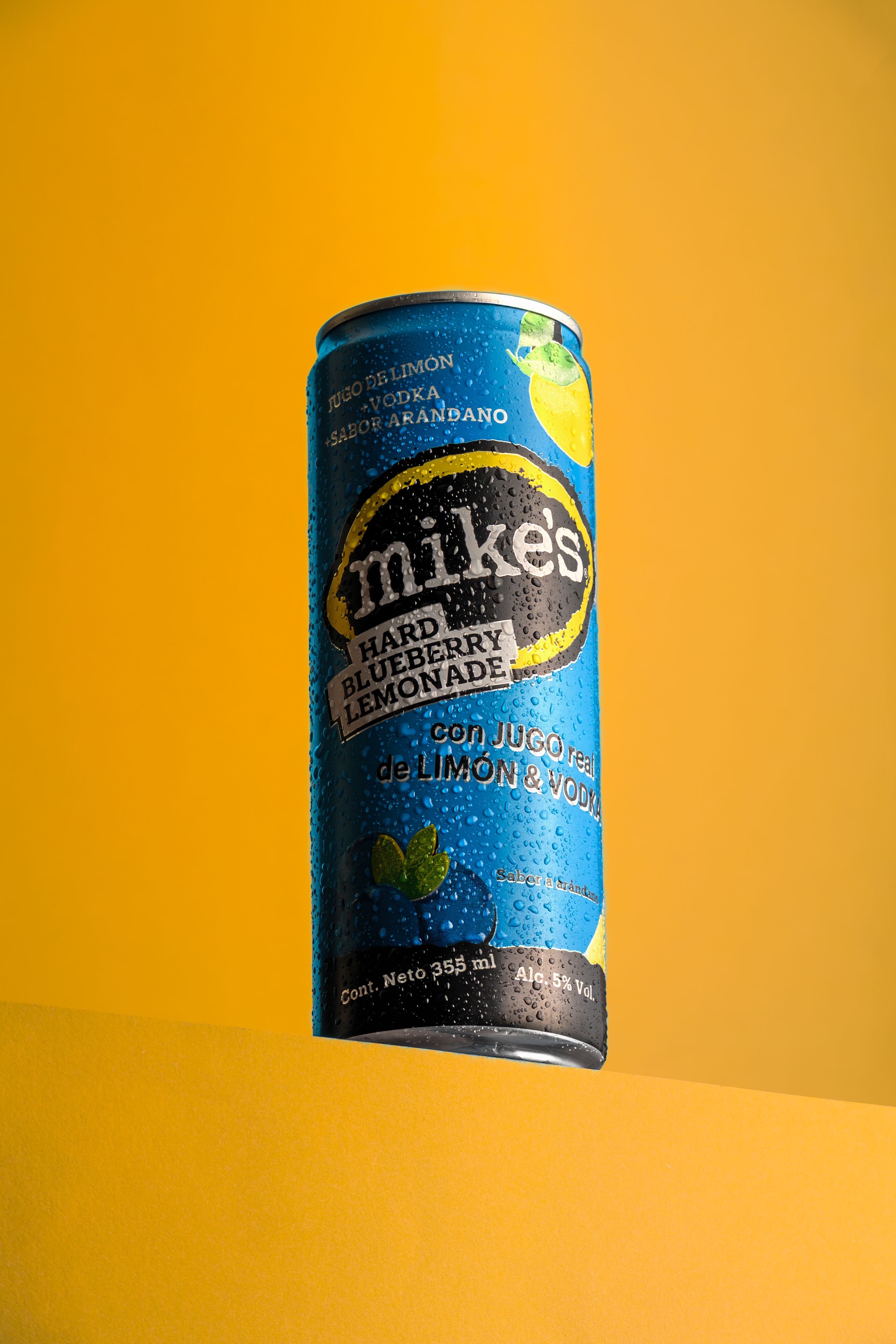 Refreshing Mike's Hard Blueberry Lemonade can against a bold yellow backdrop, perfect for beverage promotion.