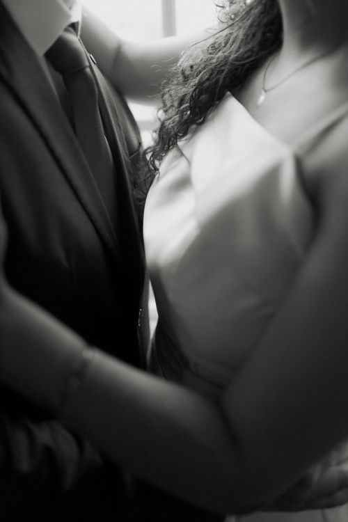 Free Intimate black and white portrait of a couple embracing at a wedding, capturing elegance and romance. Stock Photo