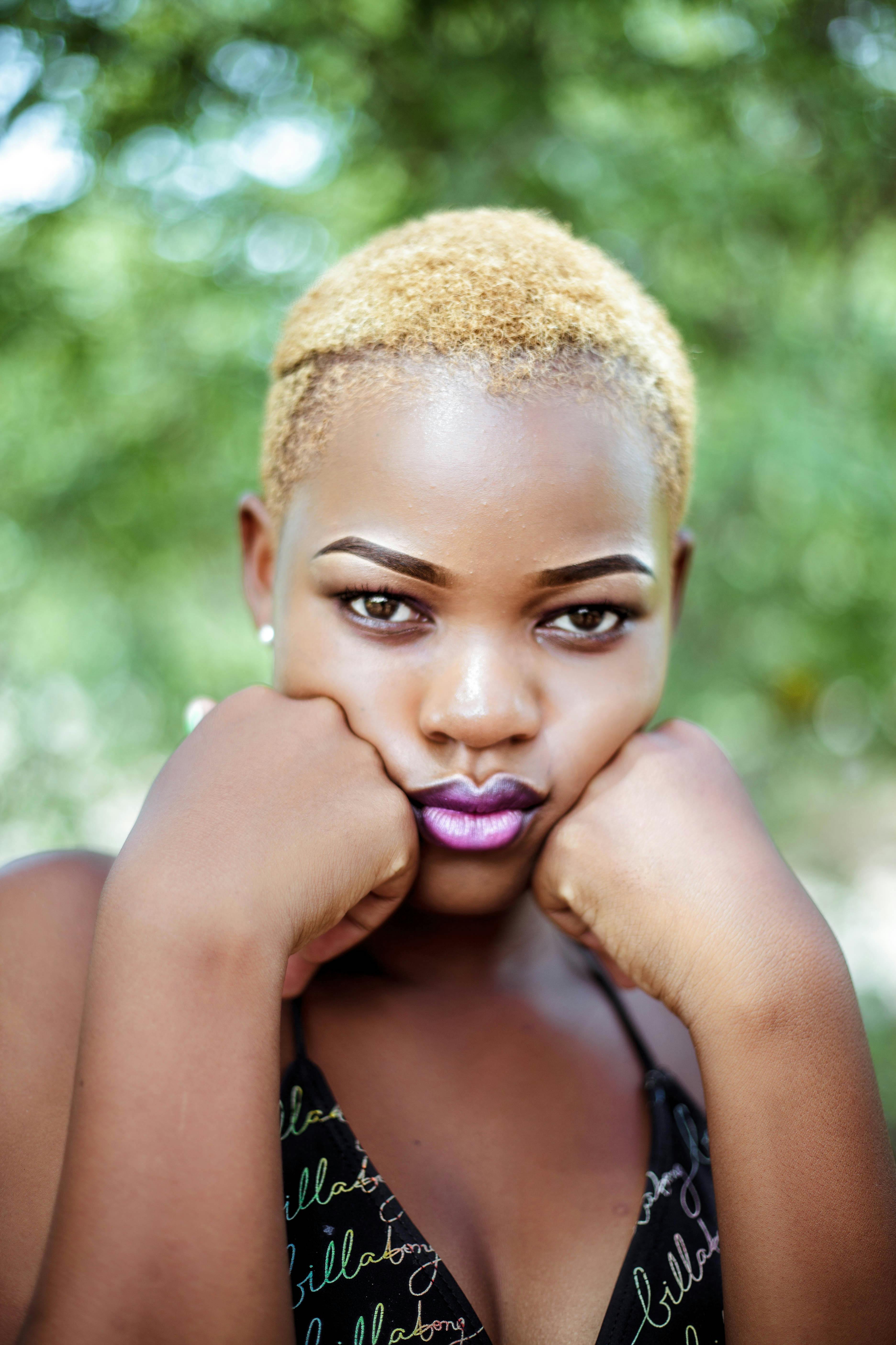 迷人的户外肖像中，一位金发黑人女性正在沉思