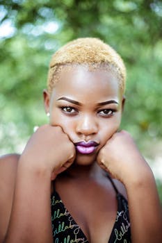 迷人的户外肖像中，一位金发黑人女性正在沉思