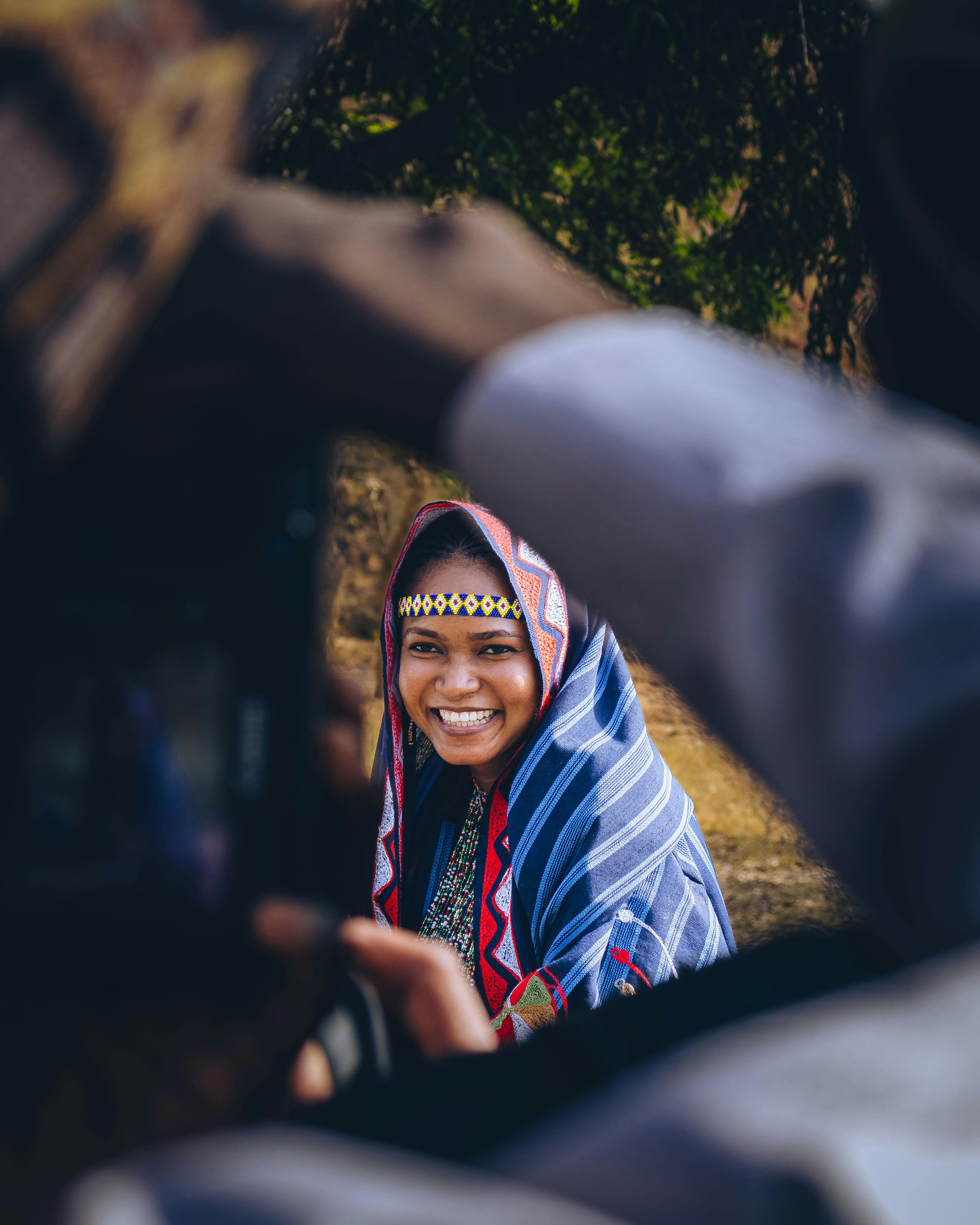 Zadarmo Radostná žena v tradičnom farebnom nigérijskom odeve vonku. Fotka z fotobanky