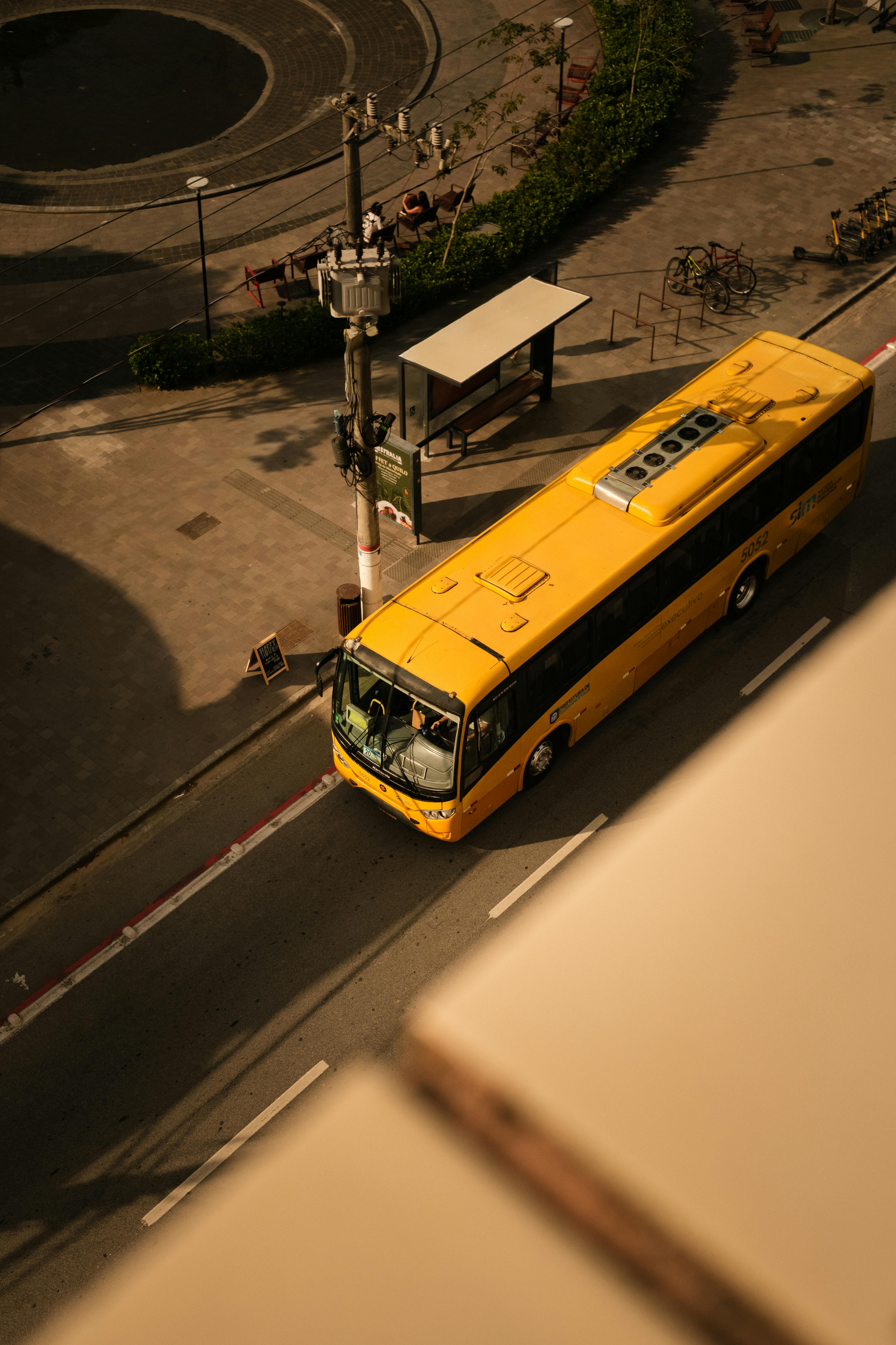 Ücretsiz Güney Karolina, Brazil'de güneşli bir şehir sokağında sarı bir otobüsü gösteren havadan çekilmiş fotoğraf. Stok Fotoğraflar