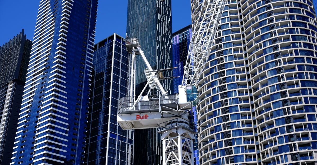 Modern skyscrapers and construction crane in urban cityscape.