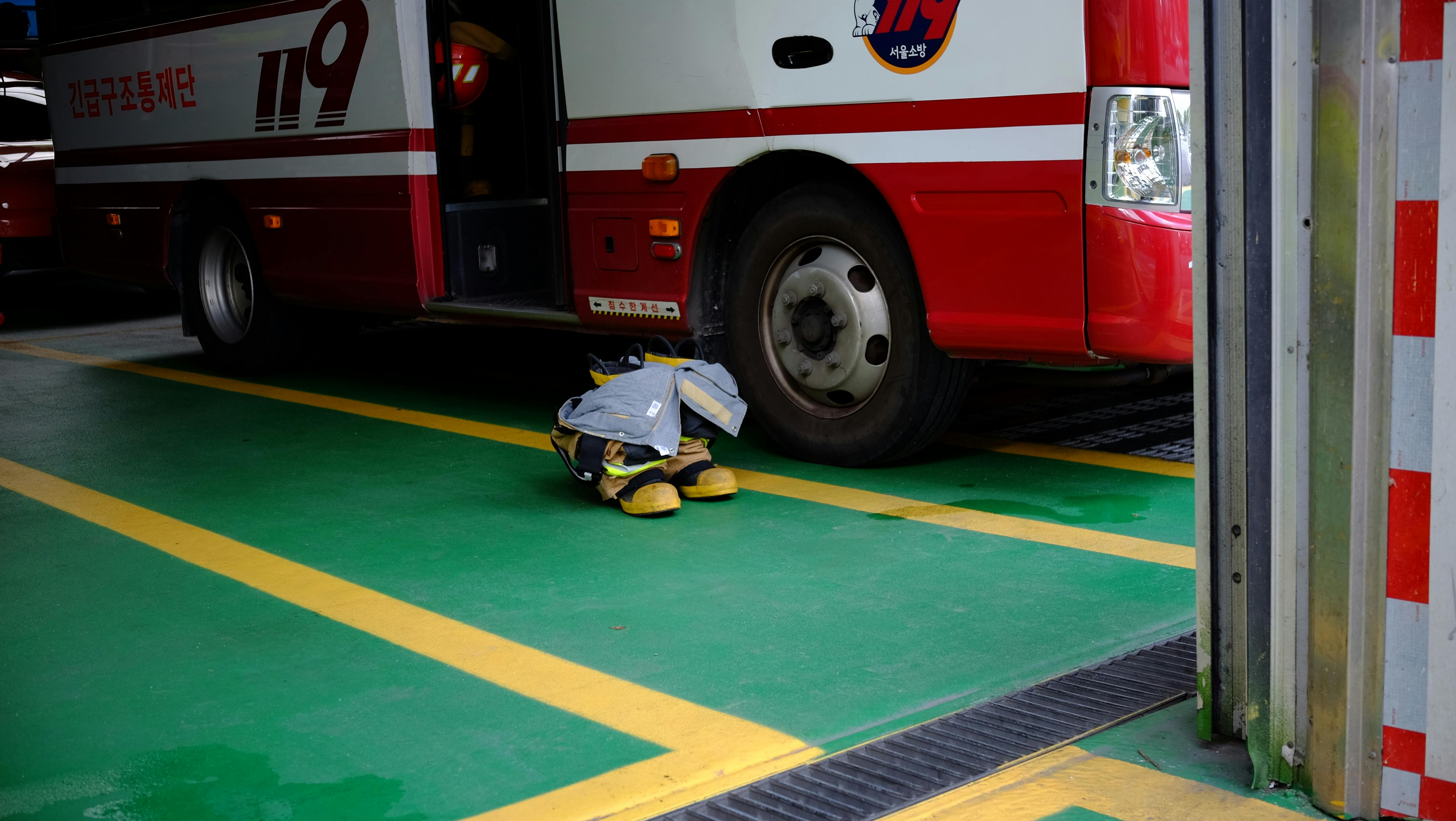 gratis Brandweeruitrusting staat opgesteld naast een hulpvoertuig in een brandweerkazerne in Seoul, Zuid-Korea. Stockfoto
