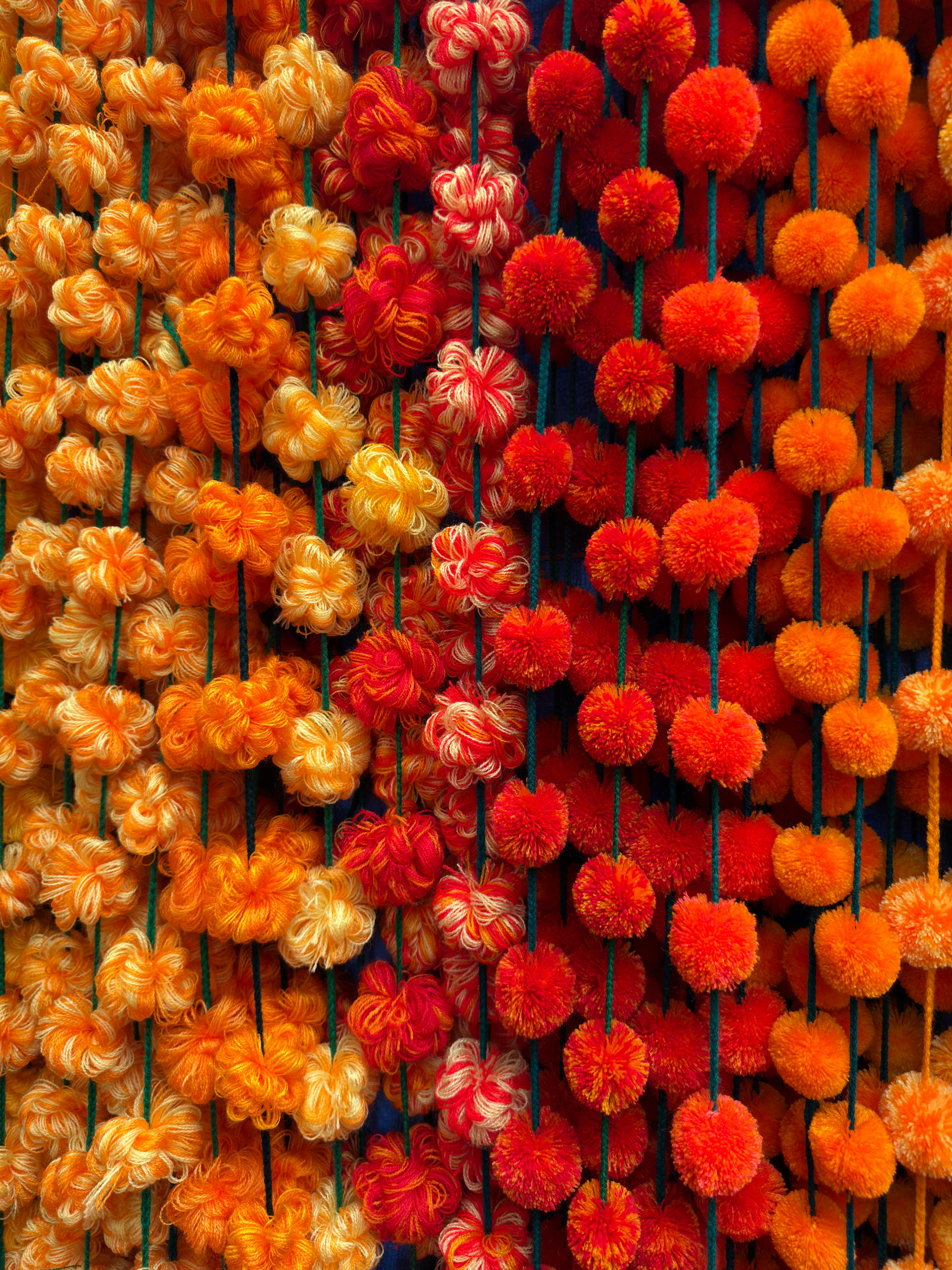 Colorful pom poms hanging in Oaxaca, showcasing Mexican craftsmanship and vibrant culture.