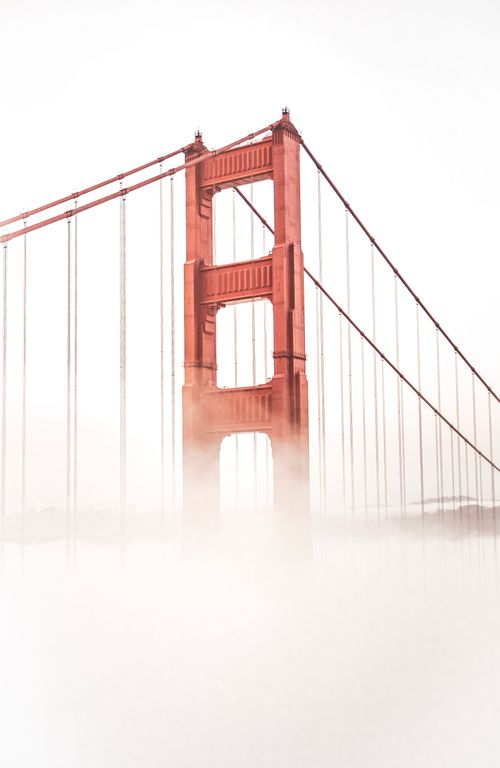 Free Iconic view of the Golden Gate Bridge rising through dense fog in San Francisco. Stock Photo