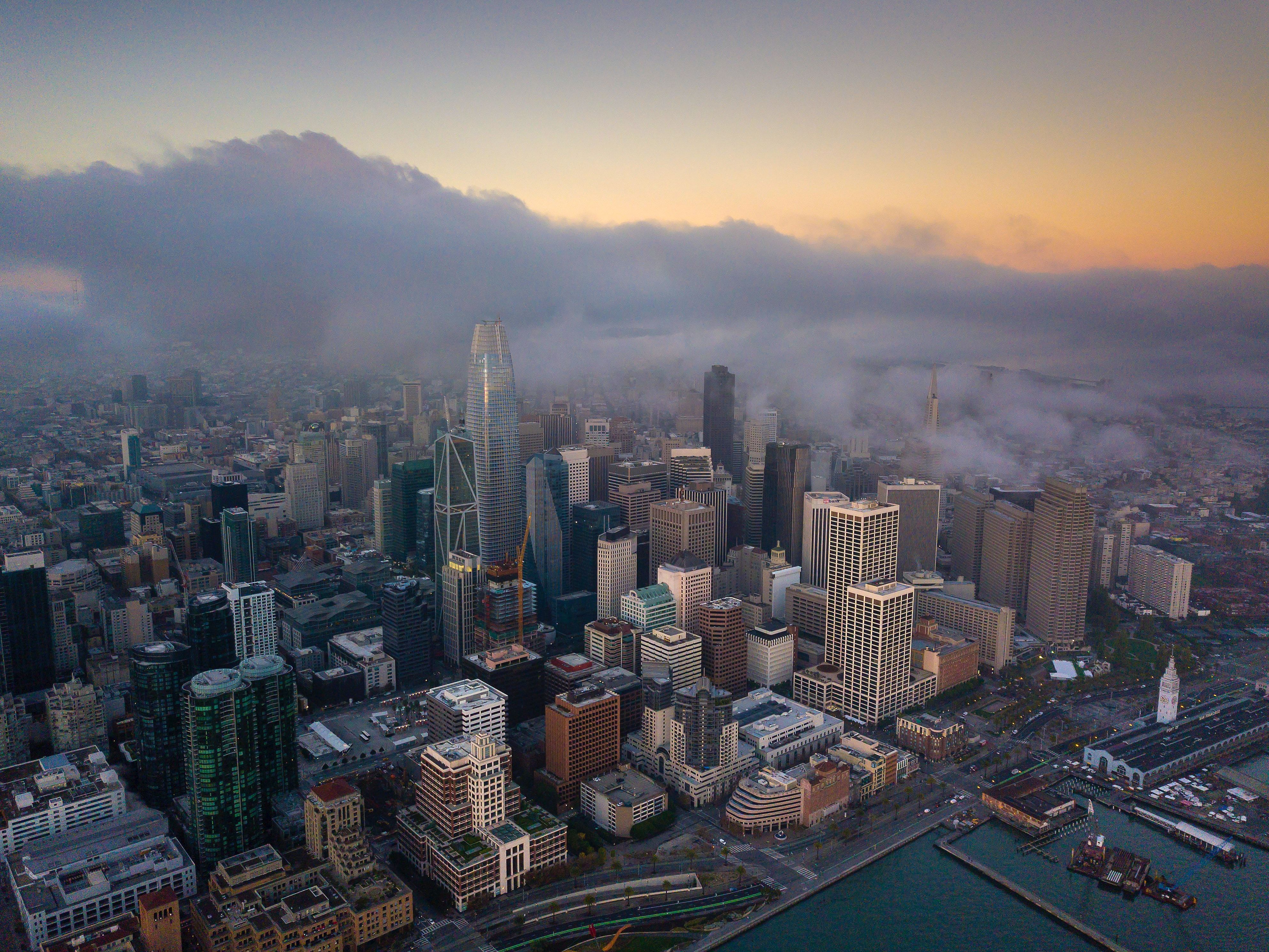 Fog moving over the San Francisco skyline at dusk.