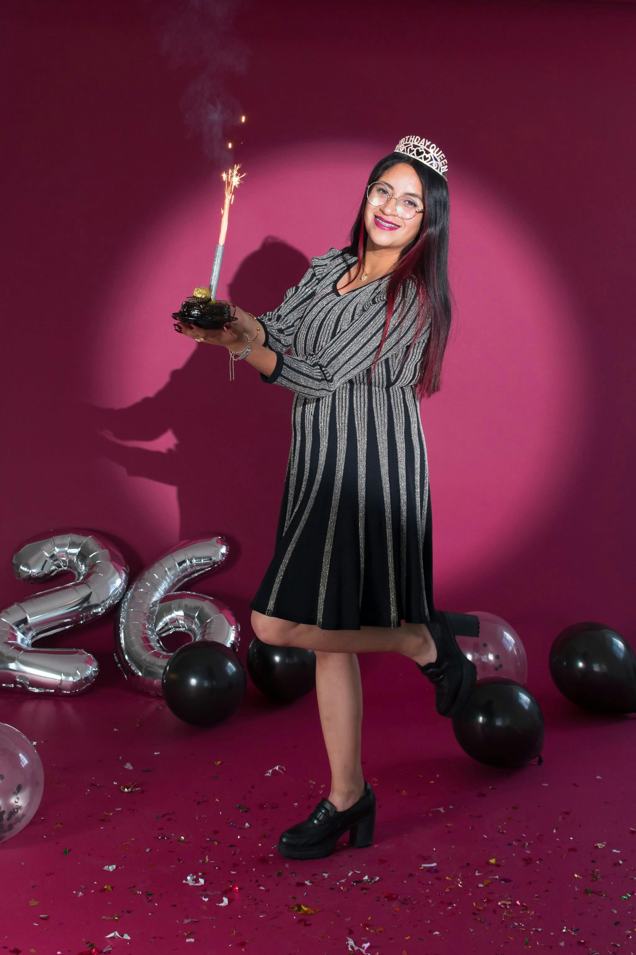 Gratis Donna che festeggia il compleanno con stelle filanti e palloncini in casa. Foto a disposizione