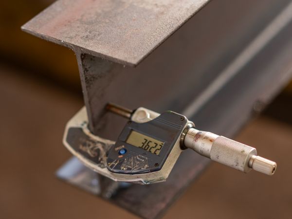 Industrial caliper measuring the thickness of a metal part