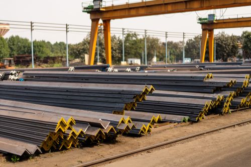 Free Numerous steel beams neatly stacked in an industrial yard during daytime. Stock Photo